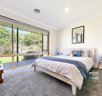 Bright and airy bedroom featuring large windows that invite natural light and offer picturesque garden views.