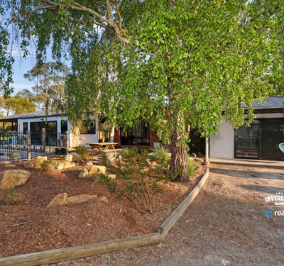 Contemporary home surrounded by lush landscaping, featuring spacious outdoor areas and modern design elements.