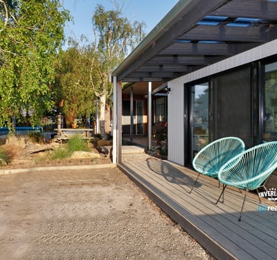 Discover this contemporary home featuring inviting outdoor seating and a spacious yard, perfect for entertaining.