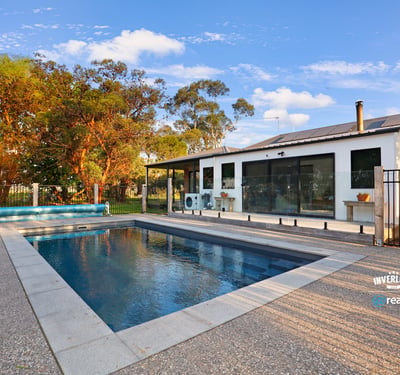 Contemporary home featuring an inviting pool area, surrounded by lush landscaping and ample outdoor space for relaxation.