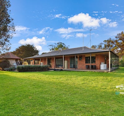Spacious home set on expansive grounds, featuring large windows and a seamless indoor-outdoor living experience.
