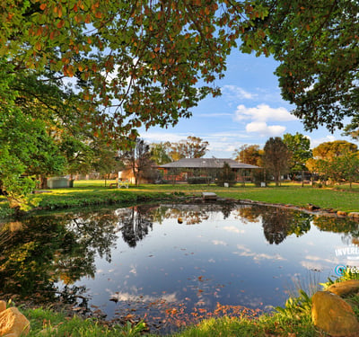 Expansive outdoor space featuring a tranquil pond, surrounded by lush greenery and scenic views.