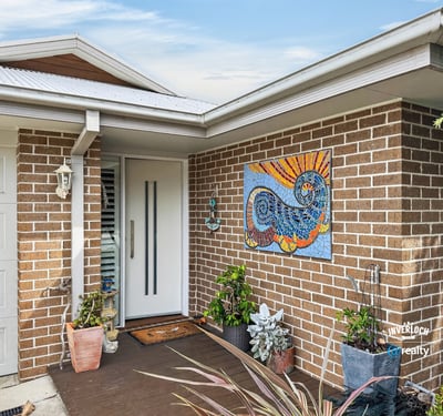 Welcoming entrance features vibrant artwork and lush greenery, offering a warm first impression to visitors.