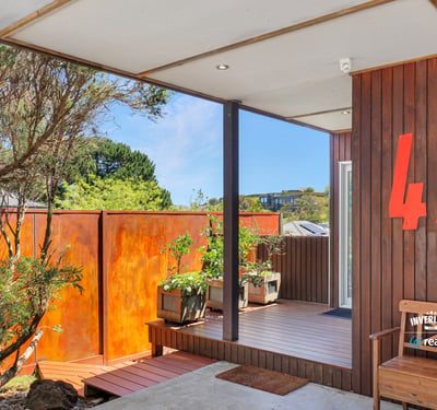 This inviting entry features unique architecture and a vibrant garden area, perfect for welcoming guests.