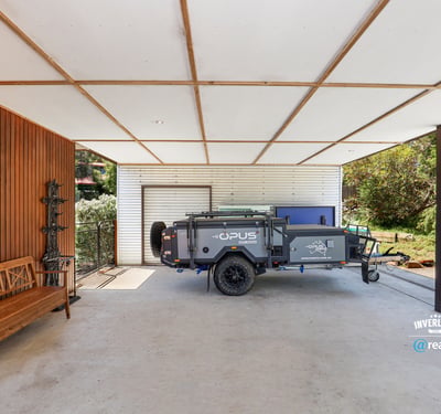 Spacious covered area perfect for storage or outdoor activities, featuring a convenient trailer setup.