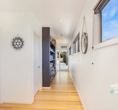 Bright and inviting hallway with seamless flow, showcasing built-in shelves and modern design elements.