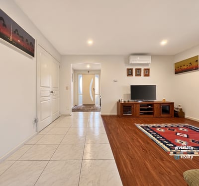 Spacious living area features tile and wood flooring, providing a warm and inviting atmosphere.