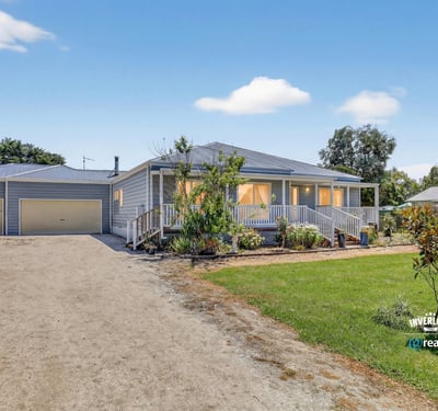 Spacious home with large yard, dual garages, and inviting porches, perfect for outdoor gatherings and relaxation.