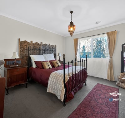 Cozy bedroom featuring unique decor, a wrought-iron bed frame, and ample natural light from the window.