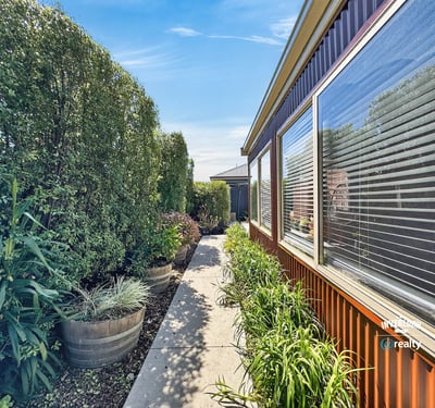 Discover a vibrant pathway lined with lush greenery, leading to inviting outdoor spaces and a welcoming atmosphere.