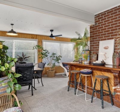 Bright sunroom featuring a cozy bar, abundant greenery, and ample natural light for relaxation and entertainment.