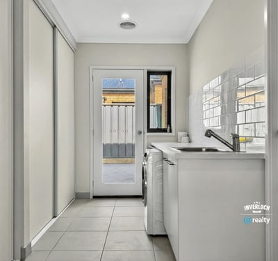 Bright and functional laundry area featuring ample storage and easy access to an outdoor space.