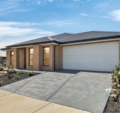 Modern home featuring a spacious driveway and large windows, perfect for natural light and convenience.
