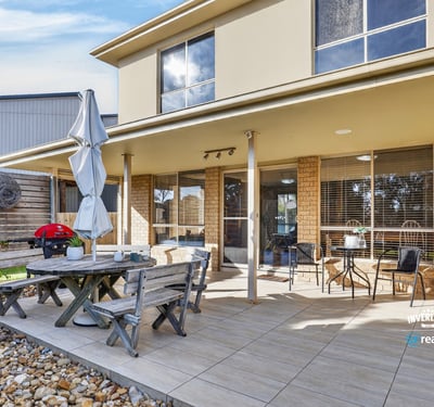 Enjoy outdoor living in this spacious backyard, featuring a patio and ample space for entertaining.