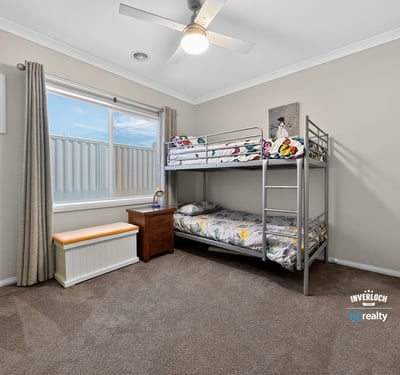 Cozy bedroom featuring a bunk bed, ample natural light, and versatile storage options.