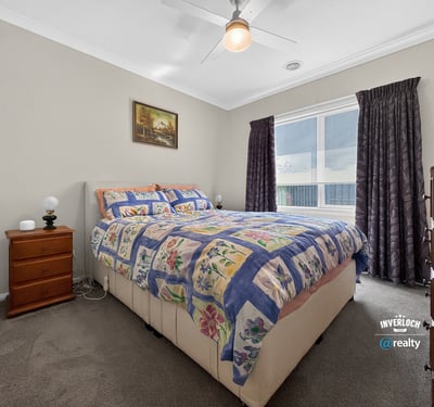 Bright bedroom featuring a spacious layout, large window for natural light, and cozy furnishings.