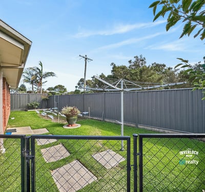 Spacious outdoor area with a fenced yard, perfect for relaxing or gardening on sunny days.