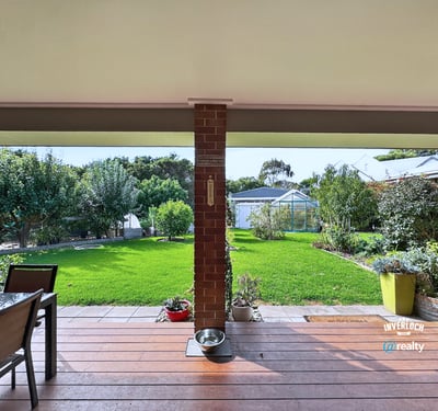 Spacious outdoor patio overlooking a vast, well-maintained garden ideal for entertaining and relaxation.