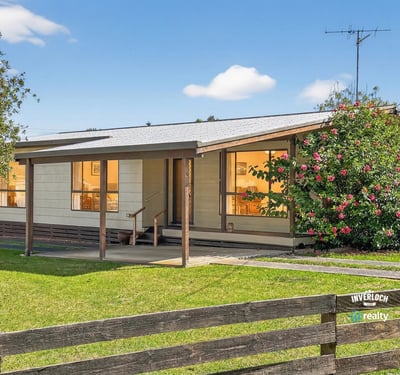 This inviting home features a spacious porch and well-maintained landscaping, perfect for outdoor relaxation.