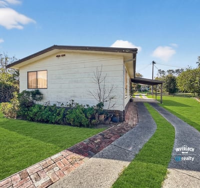 Modern home featuring a spacious yard and inviting pathway, perfect for outdoor entertaining and relaxation.
