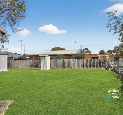Spacious backyard with ample green space and a functional shed, ideal for outdoor activities and storage.