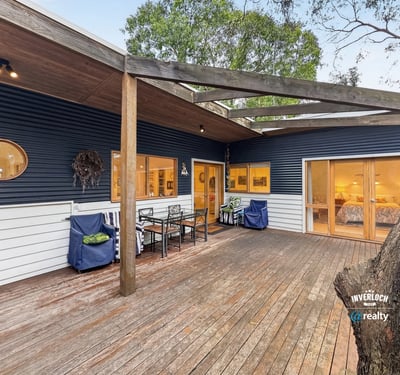 Contemporary home featuring a spacious outdoor deck, perfect for entertaining in a natural setting.