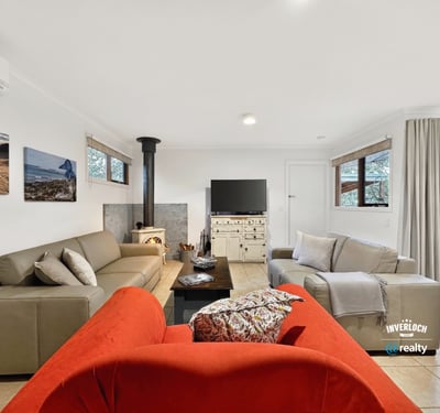 Bright living space featuring natural light, a wood-burning stove, and direct access to outdoor areas.