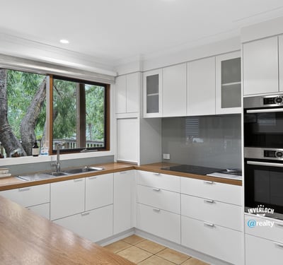 Modern kitchen featuring sleek cabinetry, quality appliances, and abundant natural light from large windows.