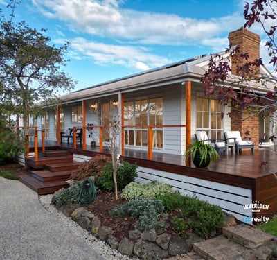 Inviting home features a spacious deck, landscaped garden, and picturesque setting, perfect for outdoor living.