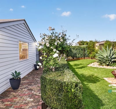 Discover a well-maintained outdoor space featuring lush greenery and a cozy fire pit for gatherings.