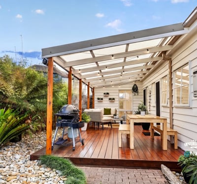 Spacious covered patio with ample seating and outdoor grilling area, perfect for entertaining and relaxing.