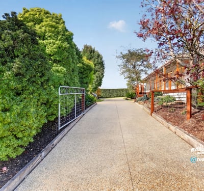 Discover this inviting pathway leading to a beautifully landscaped property, ideal for your future home.