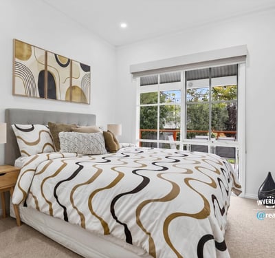 Bright bedroom featuring large windows, modern decor, and a cozy layout, ideal for relaxation and rest.