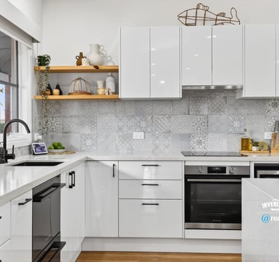 Modern kitchen featuring sleek cabinetry, advanced appliances, and eye-catching tile backsplash for a contemporary culinary experience.