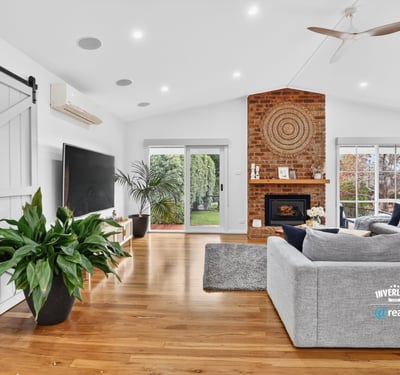 Bright, open living space featuring a distinctive brick fireplace and inviting natural light throughout.