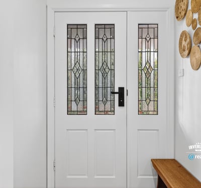 Inviting entryway featuring detailed glass doors and unique wall decor, perfect for welcoming guests.