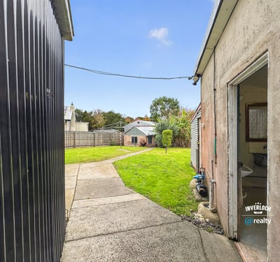 Spacious backyard with landscape potential, featuring accessible pathways and neighboring properties for a vibrant community feel.
