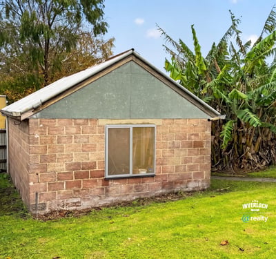 This property offers a unique renovation opportunity amid a spacious backyard surrounded by lush greenery.