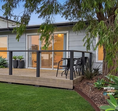 This property features a spacious deck surrounded by lush landscaping, perfect for outdoor relaxation and entertaining.