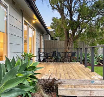 Discover a welcoming outdoor space featuring a spacious deck and lush greenery, perfect for relaxation.