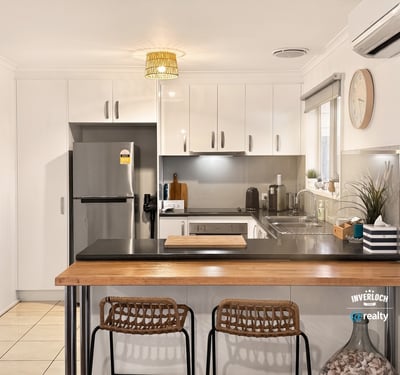 Bright kitchen featuring modern appliances, sleek cabinetry, and a cozy breakfast bar for casual dining.