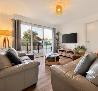 Bright living area features modern furnishings and large sliding doors that open to a scenic outdoor space.