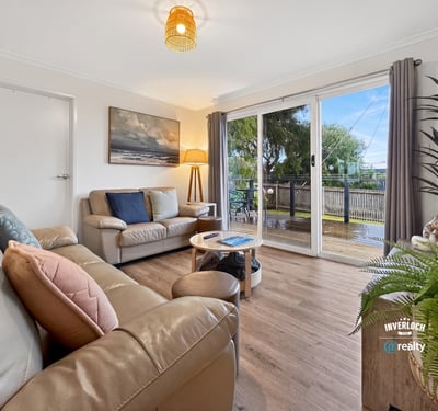 Bright and inviting living space featuring large windows, a cozy atmosphere, and easy outdoor access.