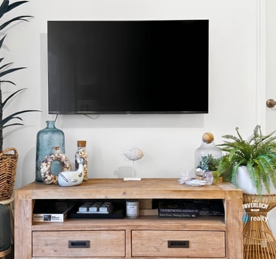 Modern living area featuring a sleek TV setup with tasteful decor and natural accents.