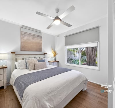 Bright, airy bedroom featuring natural light, modern decor, and a view of lush greenery outside.