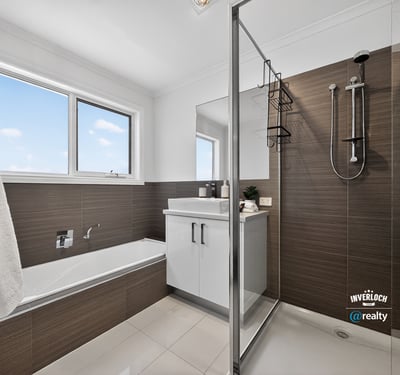 Modern bathroom featuring a glass shower, freestanding tub, and ample natural light from large windows.