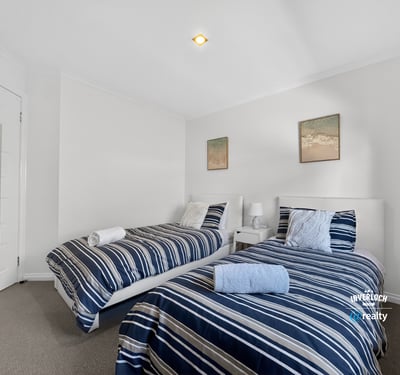 Bright and inviting twin bedroom featuring modern decor and comfortable furnishings for a relaxing stay.
