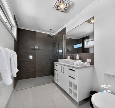 Modern bathroom featuring sleek finishes, spacious layout, and abundant natural light, perfect for relaxation.