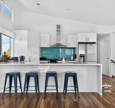 Modern kitchen featuring a striking turquoise backsplash, sleek cabinetry, and ample counter space for entertaining.