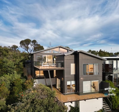Contemporary home nestled in nature, featuring expansive decks and large windows that invite abundant natural light.